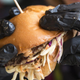 A woman in black gloves holds a hamburger in a Black Star Burger in Grozny, Chechen Republic, Russia